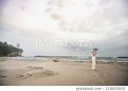 Young woman doing yoga on the beach 118003928