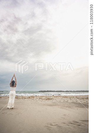 Young woman doing yoga on the beach 118003930