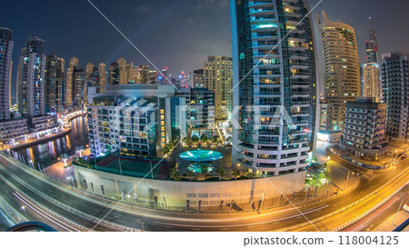 Dubai Marina at night timelapse with light trails of boats on the water and cars, Dubai, UAE Dubai Marina at night timelapse with light trails of boats on the water and cars, Dubai, UAE 118004125