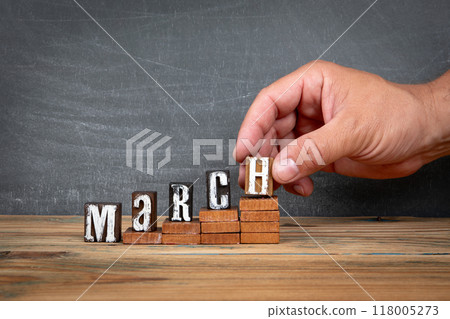 MARCH. Wooden letters, alphabet blocks on steps. development and growth concept 118005273