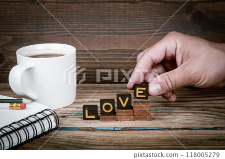 LOVE. Old letter tiles on wooden steps, development concept 118005279