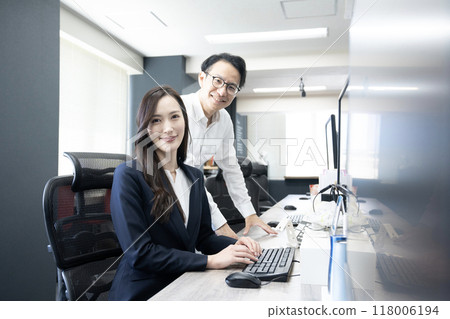 Male and female employees looking at the camera 118006194