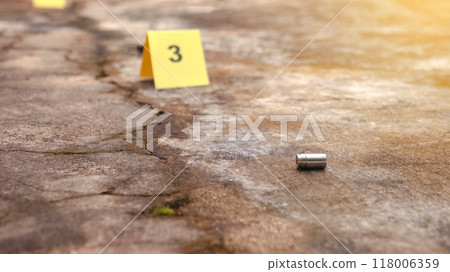 Spent bullet casing lying on the ground with blur number 3 sign. Concepts of shooting sports and security highlighting the dual nature of firearms in both competitive sport and protective measures. Spent bullet casing lying on the ground with blur number 3 sign. Concepts of shooting sports and security highlighting the dual nature of firearms in both competitive sport and protective measures. 118006359