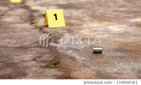 Spent bullet casing lying on the ground with blur number 1 sign. Concepts of shooting sports and security highlighting the dual nature of firearms in both competitive sport and protective measures. Spent bullet casing lying on the ground with blur number 1 sign. Concepts of shooting sports and security highlighting the dual nature of firearms in both competitive sport and protective measures. 118006361