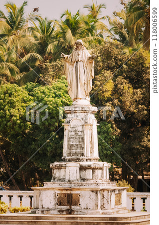 Old Goa, India. Cathedral Of St. Paul And Statue Of Jesus In Sunny Day Old Goa, India. Cathedral Of St. Paul And Statue Of Jesus In Sunny Day 118006599