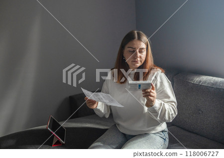 Caucasian woman holds nasal swab and puts into nose for COVID-19 self test at home Caucasian woman holds nasal swab and puts into nose for COVID-19 self test at home 118006727