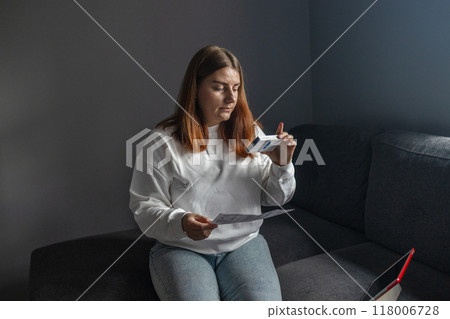 Caucasian woman holds nasal swab and puts into nose for COVID-19 self test at home Caucasian woman holds nasal swab and puts into nose for COVID-19 self test at home 118006728