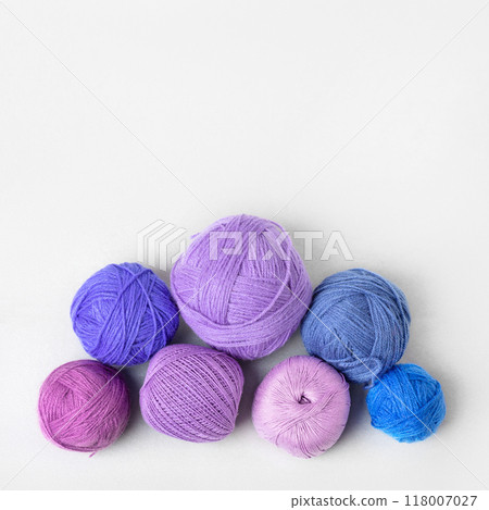 Purple and blue knitting threads of different shades on a gray background. Pattern of balls of thread. Concept needlework. Flat lay Purple and blue knitting threads of different shades on a gray background. Pattern of balls of thread. Concept needlework. Flat lay 118007027