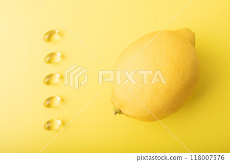 Vitamin C pills. Supplement soft capsule isolated on yellow background. Lemon and vitamins in soft capsule. Treatment and prevention of flu and colds. Healthcare concept banner. High quality photo Vitamin C pills. Supplement soft capsule isolated on yellow background. Lemon and vitamins in soft capsule. Treatment and prevention of flu and colds. Healthcare concept banner. High quality photo 118007576