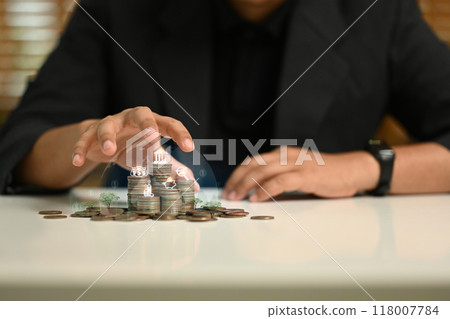 Hand reaching toward a stack of coins on table. Personal finance, investment strategies and financial planning concept 118007784