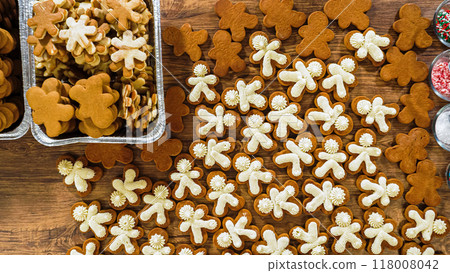 Flat lay. Crafting gingerbread cookie sandwiches with eggnog buttercream, presented on a rustic wooden table for Christmas gifting. 118008042