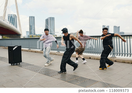 Dancing Group Performing Hip-Hop Routine Outdoors Dancing Group Performing Hip-Hop Routine Outdoors 118009373