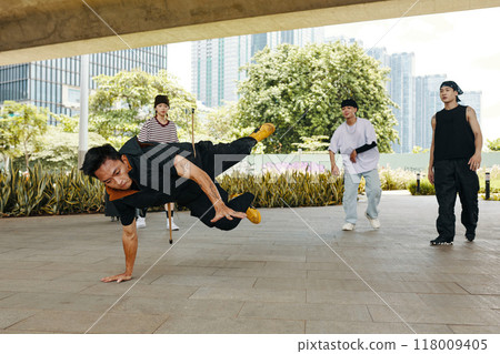 Group of Breakdancers Performing Complex Moves Outdoors 118009405