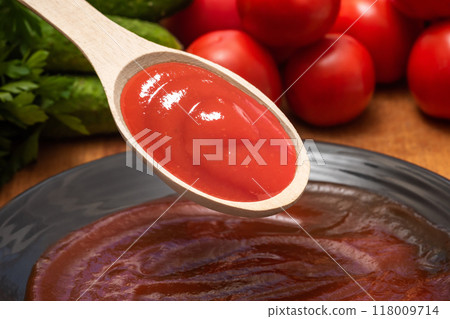 Spoon of ketchup or tomato sauce in kitchen, close-up 118009714