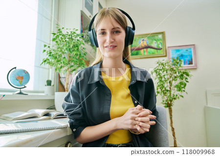 Teenage student girl in headphones having video conference, at home, webcam view 118009968