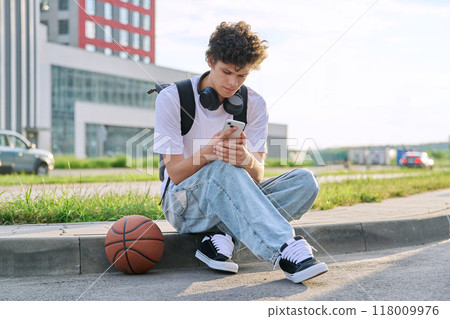 Young guy using smartphone, modern city street background 118009976