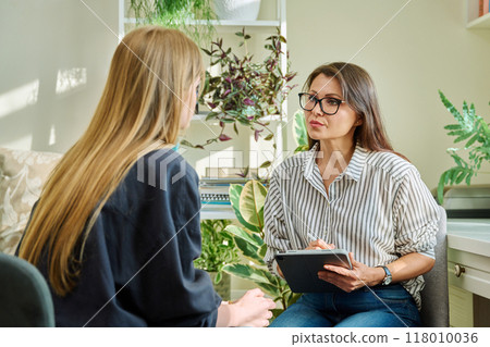 Female psychologist having therapy session with young woman Female psychologist having therapy session with young woman 118010036