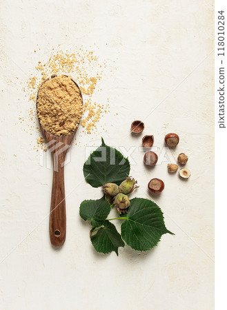 wooden spoon with hazelnut flour, top view, no people, on a white table 118010284