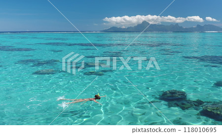 Snorkeling in clear blue waters, surrounded by tropical beauty, under a sunny sky. A dreamlike scene capturing the essence of a perfect summer vacation 118010695