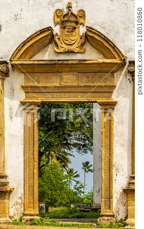 Baroque church portal overlooking tropical vegetation 118010860