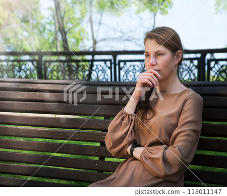 Pretty girl sitting on the bench 118011147