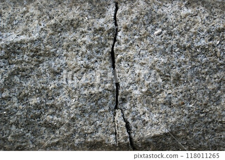 Cracked stone wall. Large crack in granite block. 118011265