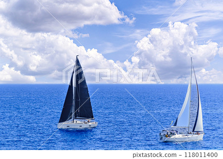 Boat, sailboat sailing on the beach of Mallorca under a blue sky with white clouds 118011400