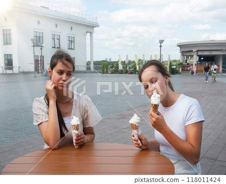 A woman looks at her friend with disapproval A woman looks at her friend with disapproval 118011424