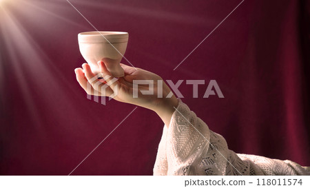 A hand in ancient clothing holds a clay bowl 118011574