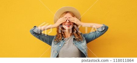 Stylish surprised young woman covering her eyes with hands in summer straw hat on orange background Stylish surprised young woman covering her eyes with hands in summer straw hat on orange background 118011864