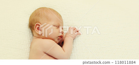 Portrait of sweet baby, infant sleeping lying on white bed at home Portrait of sweet baby, infant sleeping lying on white bed at home 118011884