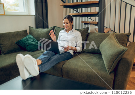 Dark-haired woman working from home and looking involved 118012226