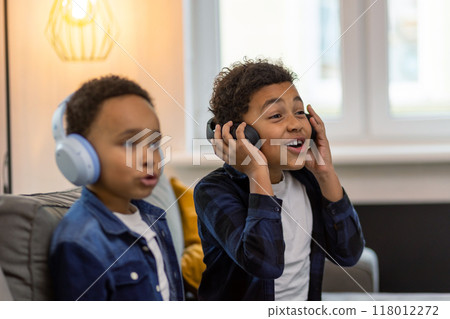 Little boys friends in wireless headphones listening to music 118012272