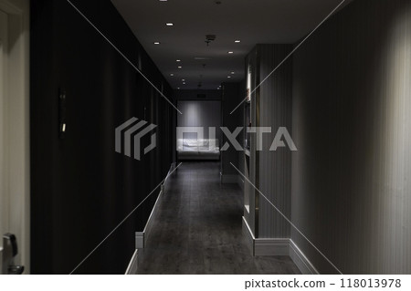 Empty hotel corridor leading to waiting area with white sofa 118013978