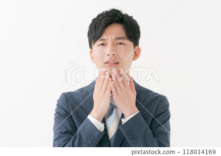 Young man with hands on face 118014169