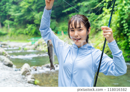 A woman fishing in a mountain stream A woman enjoying fishing 118016382