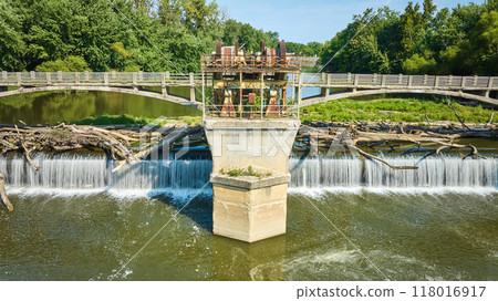 Straight on Maumee River Dam rusty gears and equipment over bridges with logs over waterfalls aerial Fort Wayne, IN 118016917