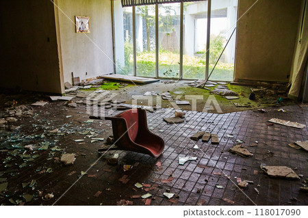 Red Chair in Abandoned Hotel Room with Overgrown View 118017090