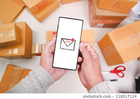 Order message symbol displayed on the white screen of the smartphone in hand Order message symbol displayed on the white screen of the smartphone in hand 118017124