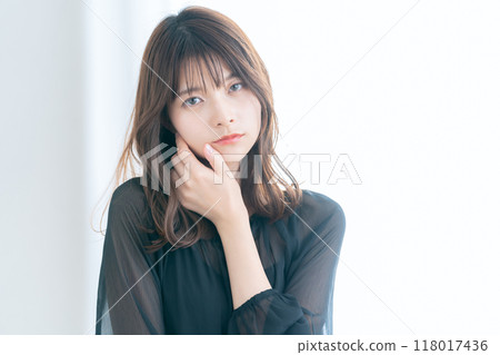 Young woman doing skin care by the window in the living room 118017436
