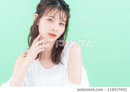 Young woman doing skin care on green background 118017442