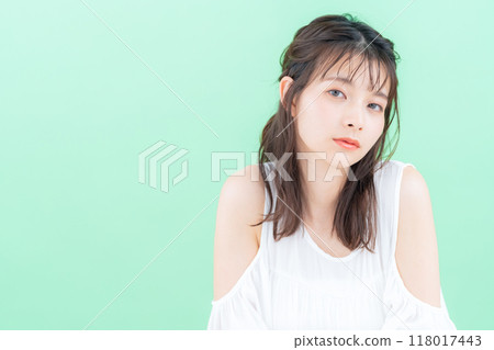 Young woman doing skin care on green background 118017443