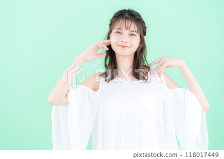 Young woman doing skin care on green background 118017449