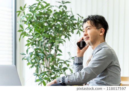 Smiling male businessman talking on a smartphone Smiling male businessman talking on a smartphone 118017597