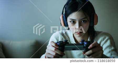 A young woman playing a game with a serious expression A young woman playing a game with a serious expression 118018050