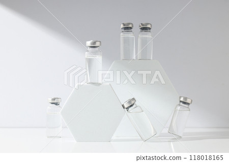 Glass medical bottles with vaccine and decorative blocks on white background 118018165