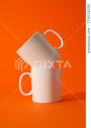 White beautiful cups on an orange background 118018200