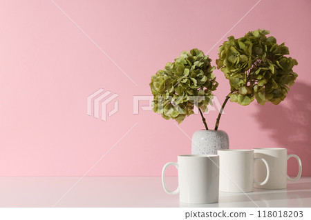White cups with green hydrangeas in a vase 118018203