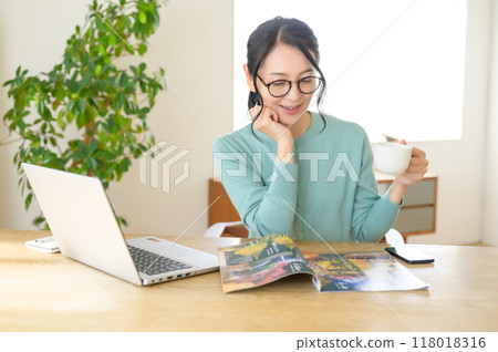 中年婦女在桌邊看小冊子 118018316