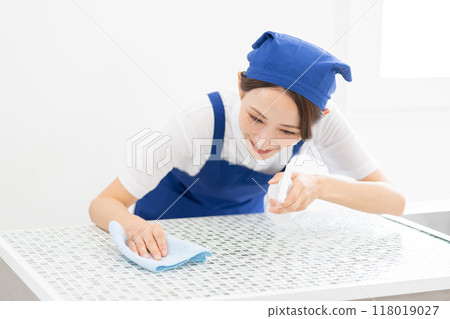 A woman from a housekeeping service cleaning the kitchen A woman from a housekeeping service cleaning the kitchen 118019027